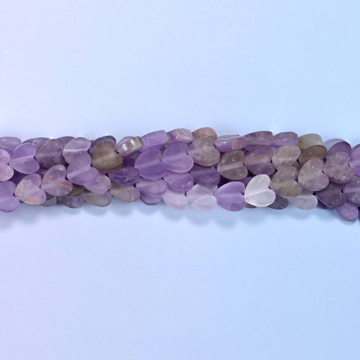 Matte amethyst flat heart beads in frosted lilac and soft grape, with smoky grey and near-white hearts mixed through.