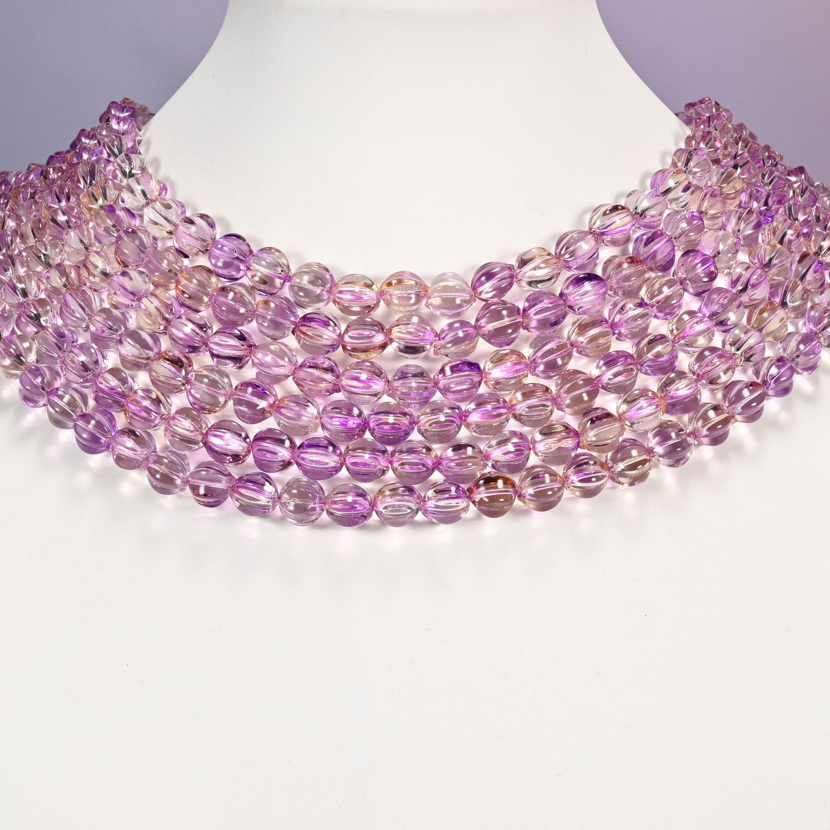 Clear purple gold pumpkin glass beads arranged as a layered collar, the 16 inch strands curving in even rows.