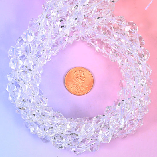 Clear Quartz diamond star cut beads coiled around a US penny, faceted rounds 6mm to 10mm