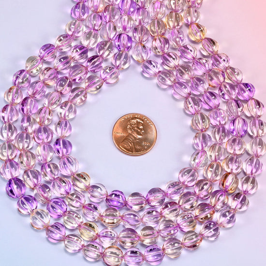 Clear purple gold pumpkin glass beads coiled flat into several concentric rings around an open center.