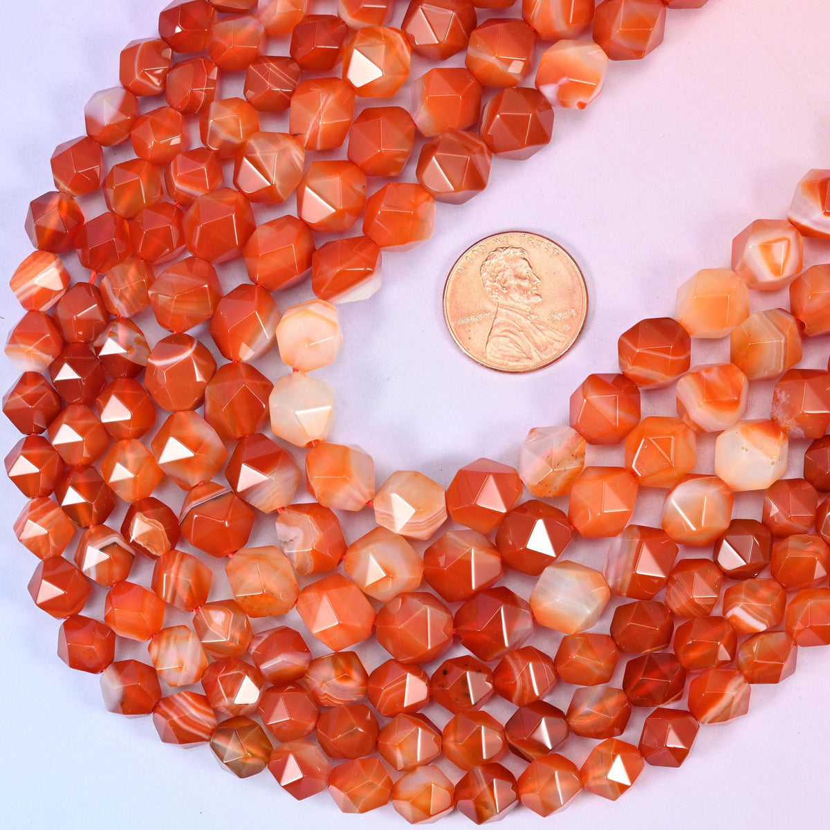 Dyed Red Stripe Agate star cut beads with a US penny alongside for size reference, available in 6mm, 8mm and 10mm