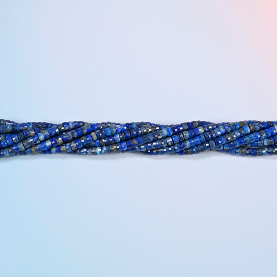 Strands of lapis faceted heishi disc beads twisted together in a horizontal row