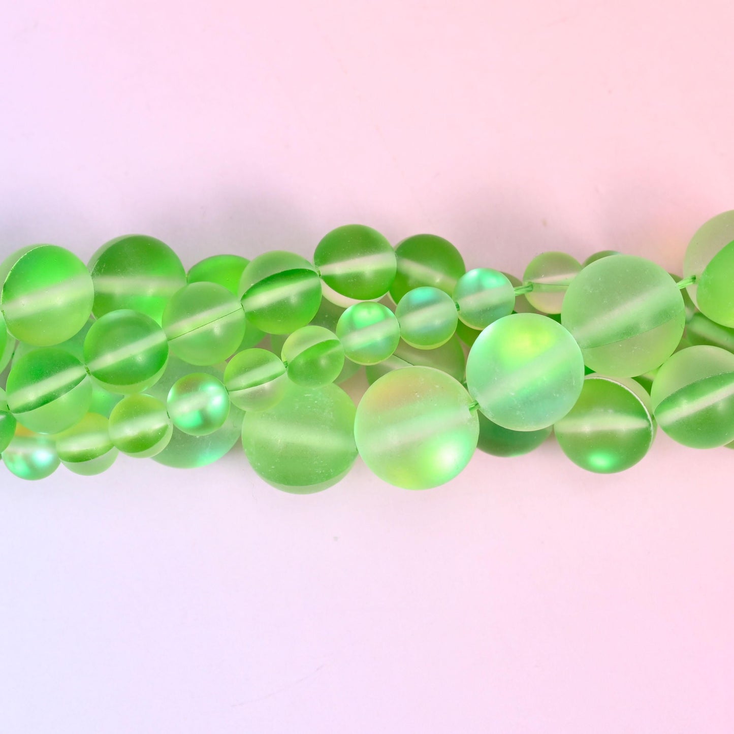 Bright apple green glass beads with a sanded frosted finish and aurora shimmer