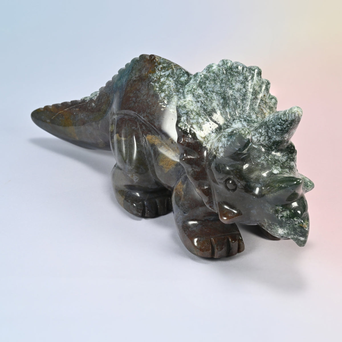 Close angle of the triceratops carving head and frill in natural green and brown Indian agate