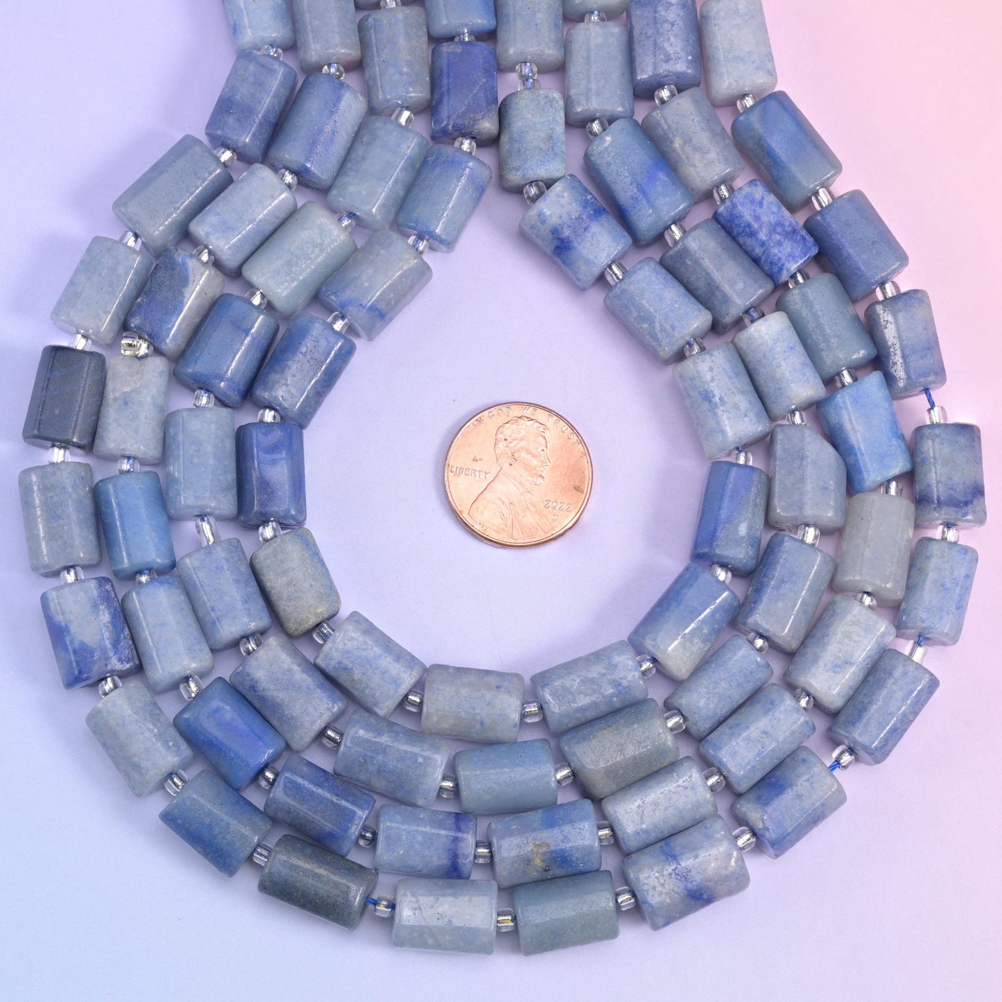 Looped aventurine tube strands circling a penny placed at the centre for scale