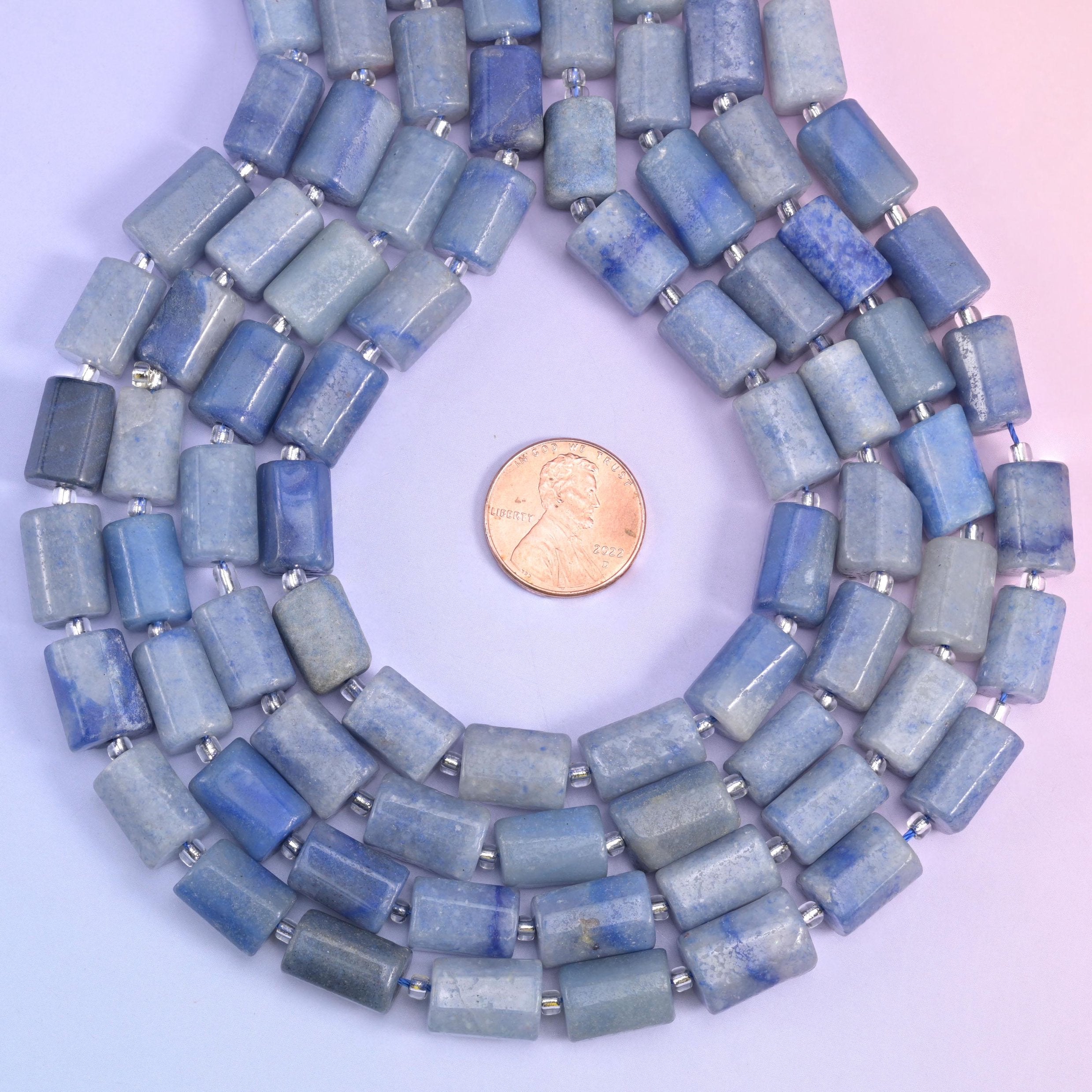 Looped aventurine tube strands circling a penny placed at the centre for scale