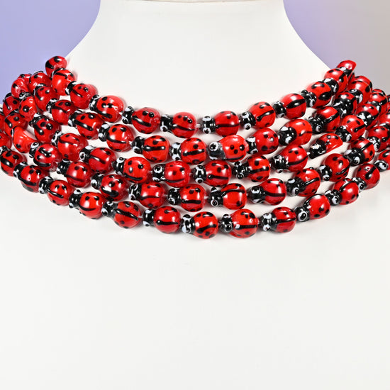 Red ladybug glass beads, approximately 13.40x9.60mm.
