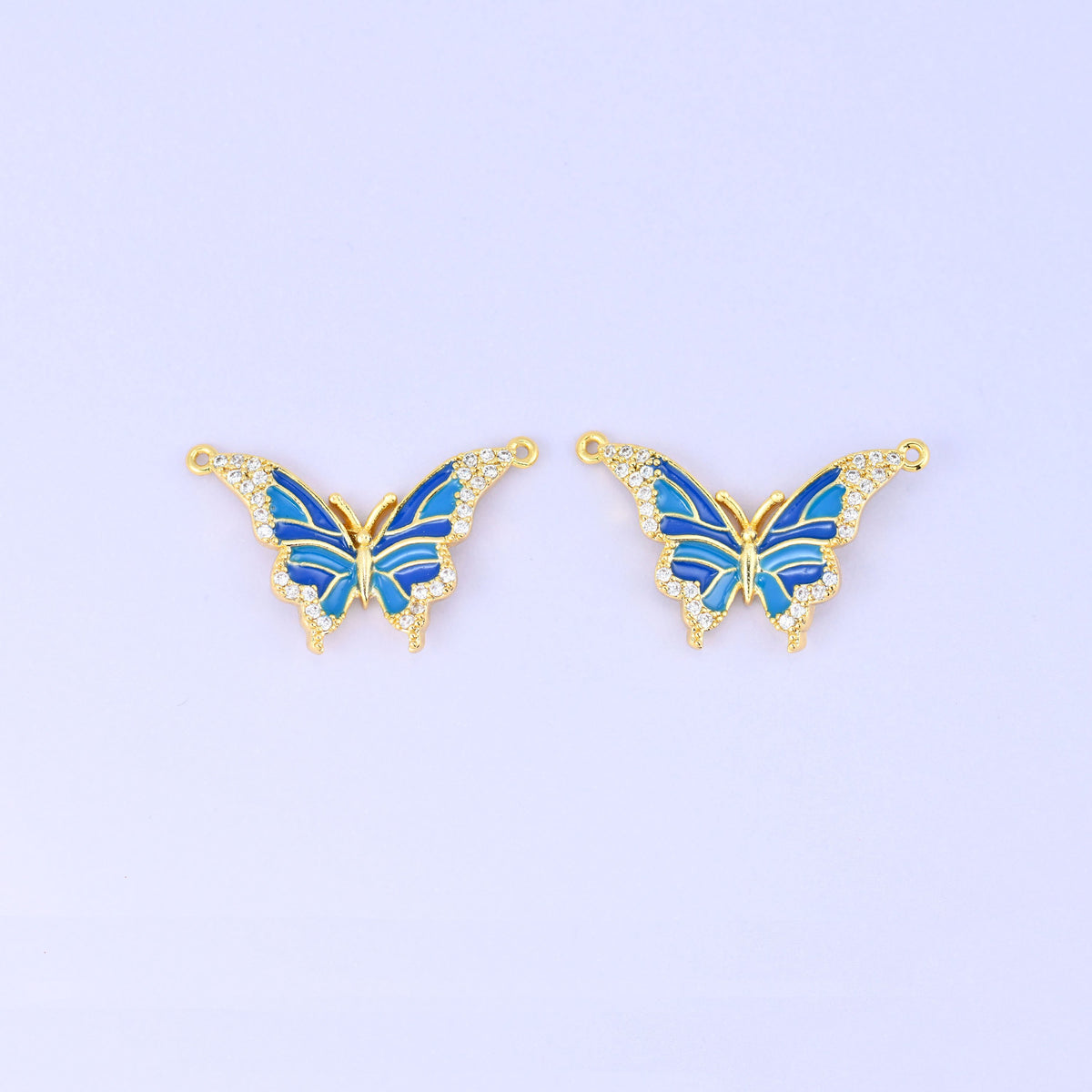 Enamel butterfly double connector pendants in blue, a matched pair of 18K gold plated butterflies with royal and sky blue wings edged in clear zircon.