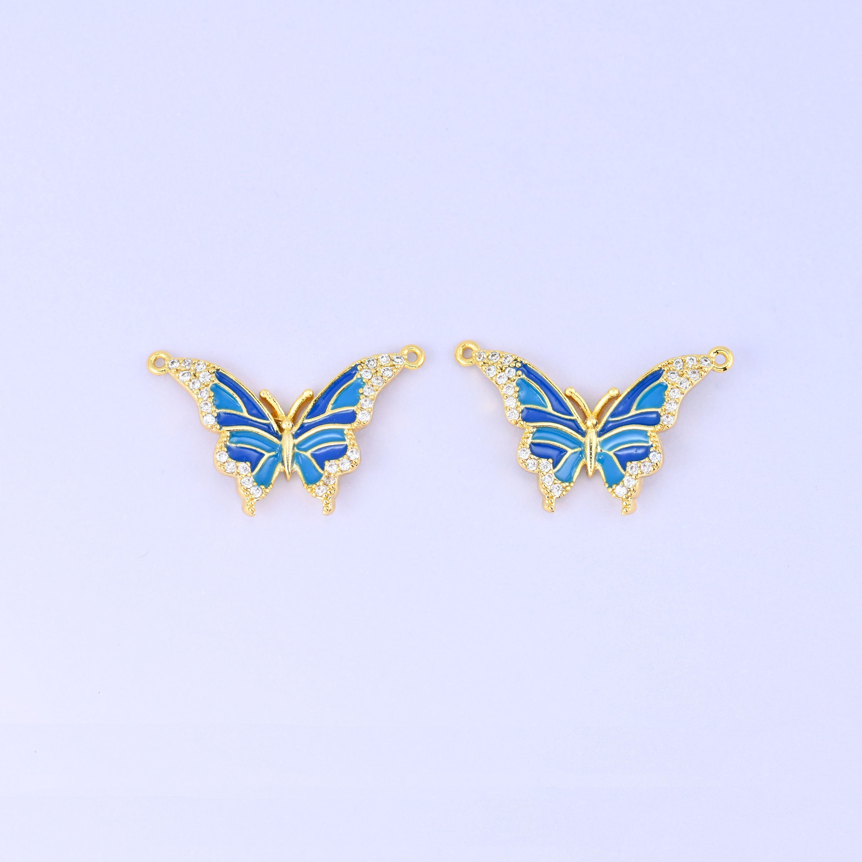 Enamel butterfly double connector pendants in blue, a matched pair of 18K gold plated butterflies with royal and sky blue wings edged in clear zircon.