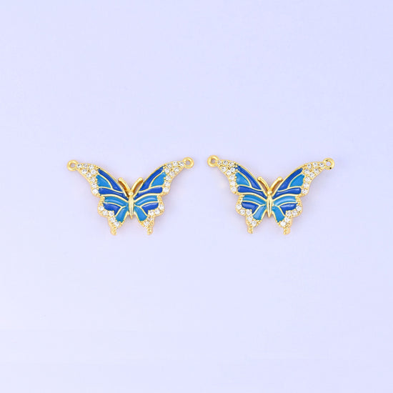 Enamel butterfly double connector pendants in blue, a matched pair of 18K gold plated butterflies with royal and sky blue wings edged in clear zircon.