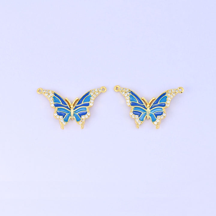 Enamel butterfly double connector pendants in blue, a matched pair of 18K gold plated butterflies with royal and sky blue wings edged in clear zirconia.
