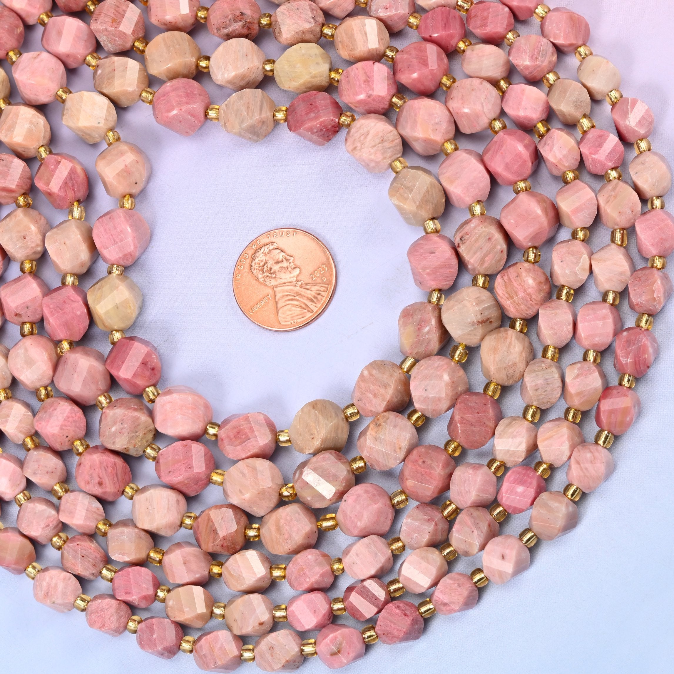 Natural Pink Rhodonite with gold-tone discs between beads