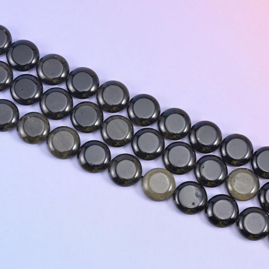 Gold Obsidian coin beads with a golden sheen across a deep black mirror finish