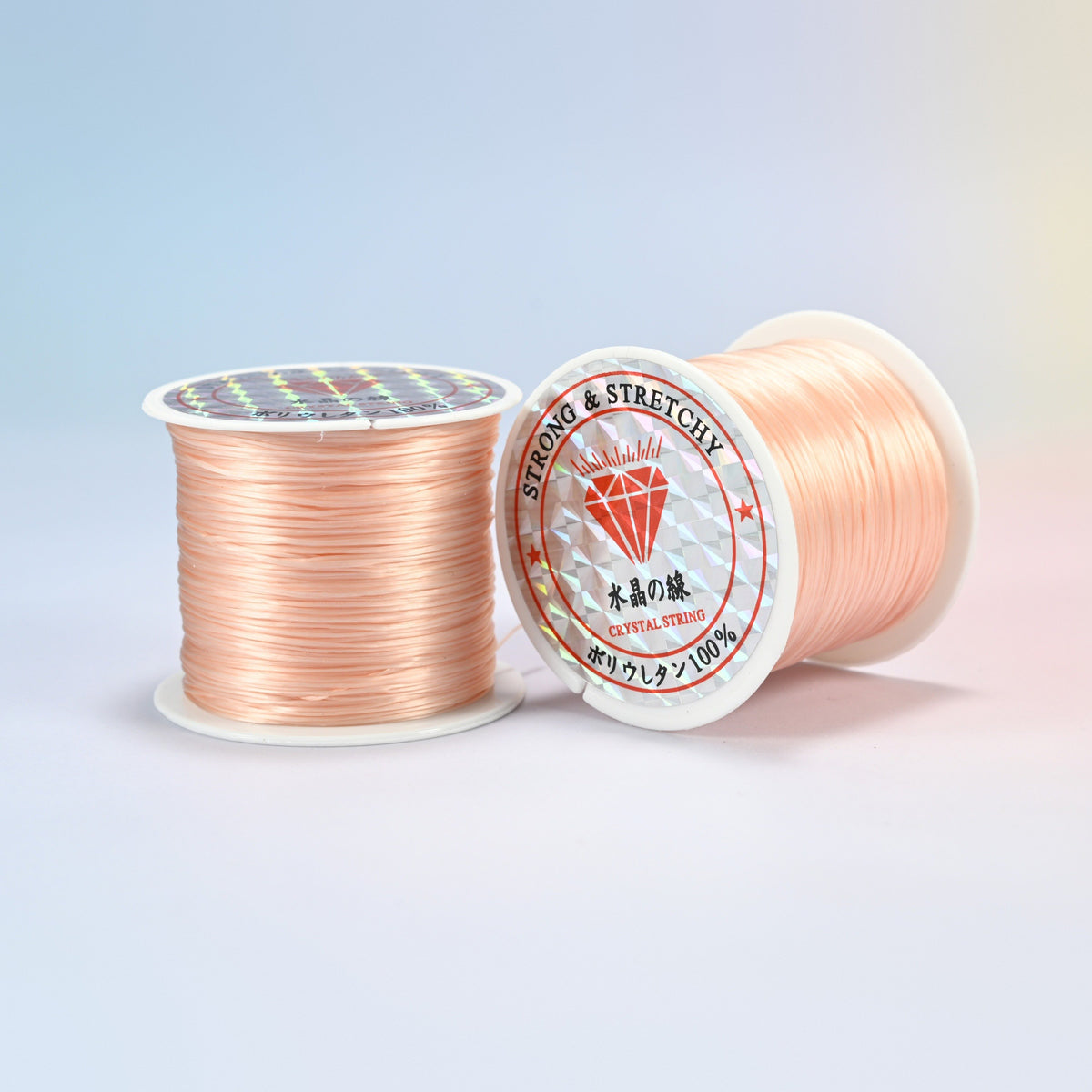 Two rolls of peach 0.7-0.8mm elastic stretch string, glossy polyurethane bead cord with a holographic label