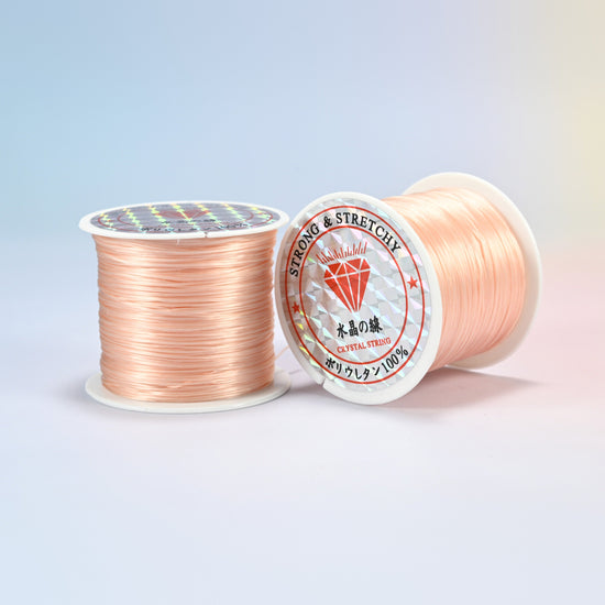 Two rolls of peach 0.7-0.8mm elastic stretch string, glossy polyurethane bead cord with a holographic label