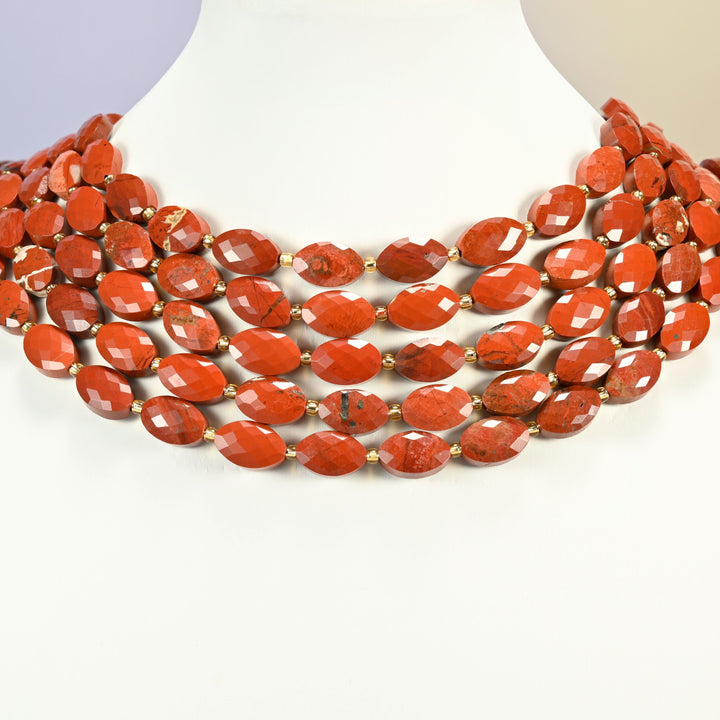 Flower red jasper faceted flat oval strands arranged as a layered collar on a white display bust, brick red beads across the neck