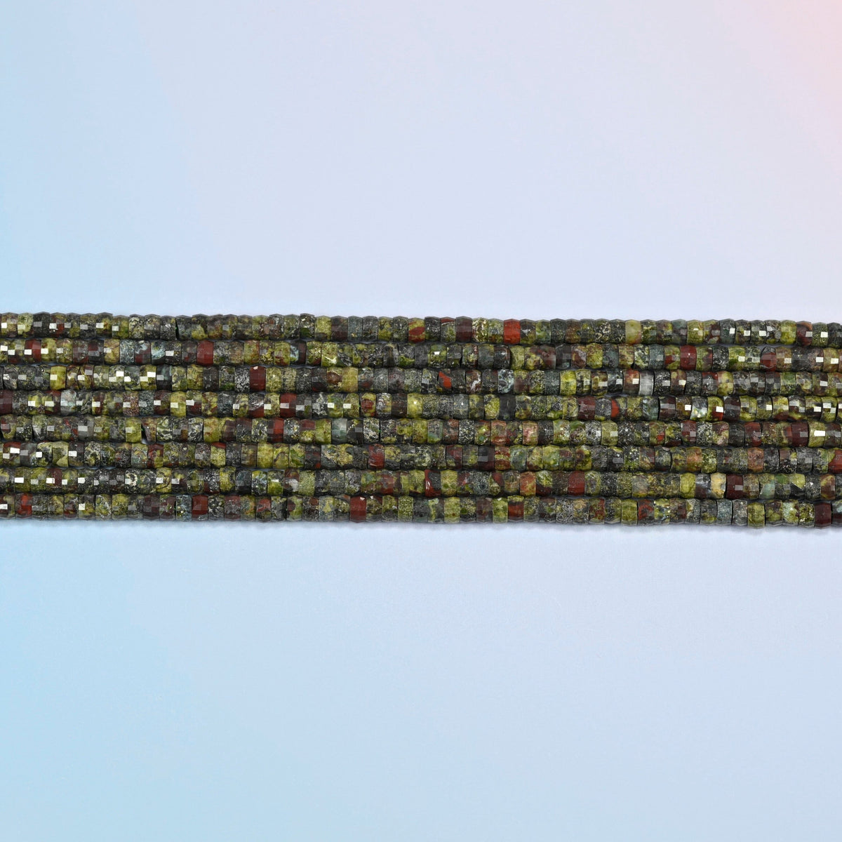 Several strands of dragon blood stone faceted heishi disc beads laid in straight rows