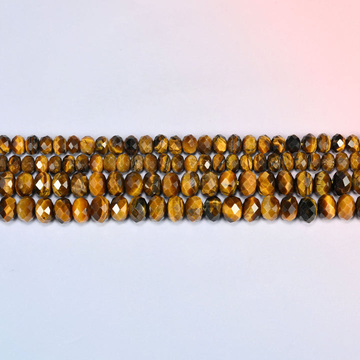 Tiger eye faceted rondelle beads laid out in straight horizontal rows on a plain background, showing the even rondelle shape and bead size