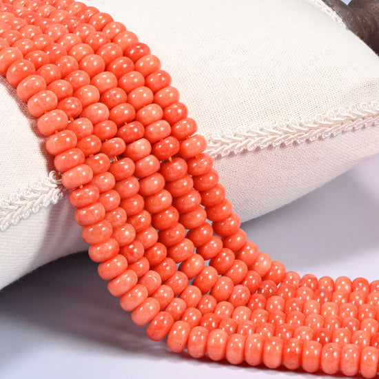 Red Orange dyed jade gemstone rondelle beads draped in rows, warm even orange discs with a glossy polish
