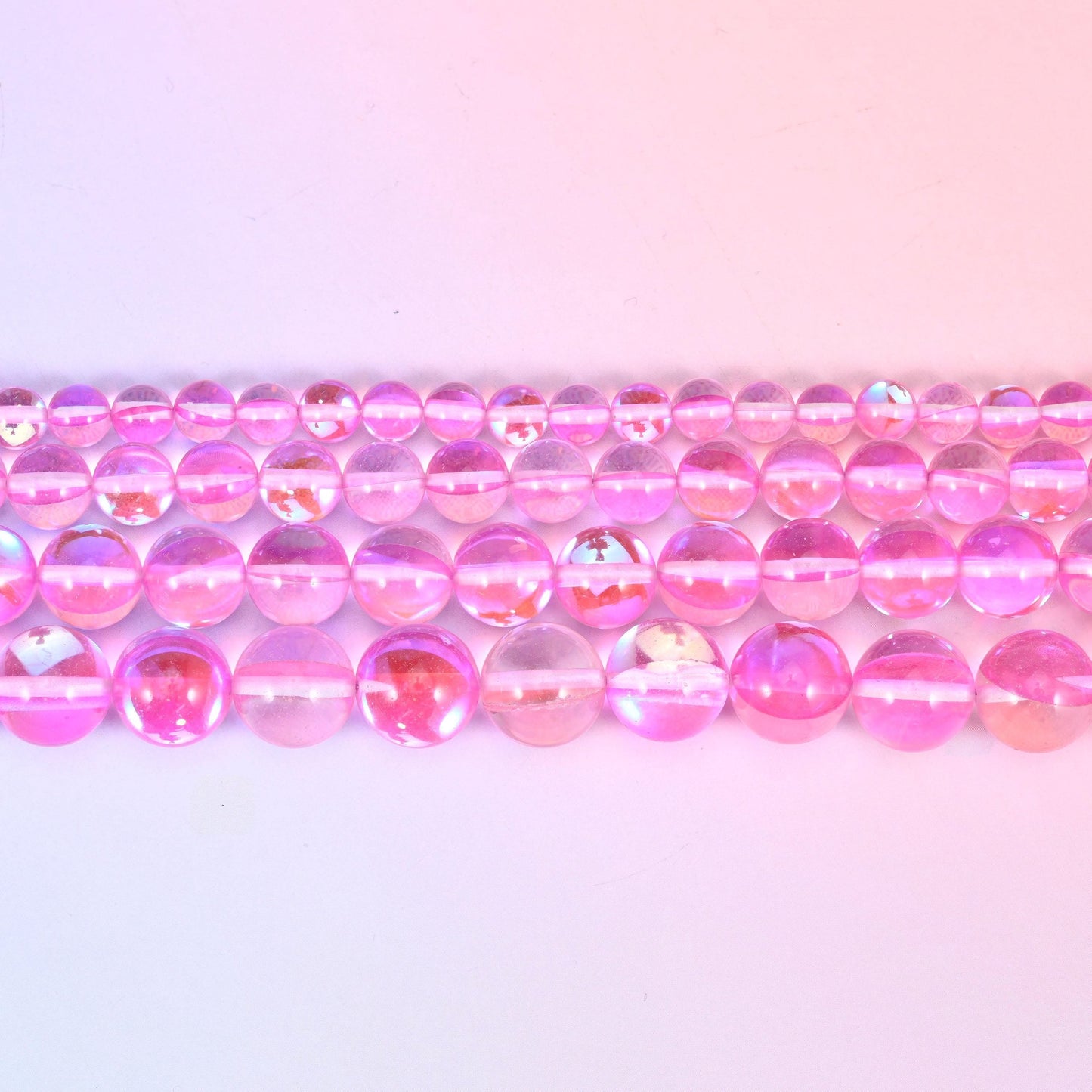 Mystic Aura beads in bubblegum-pink iridescent glass with lilac and gold shifts