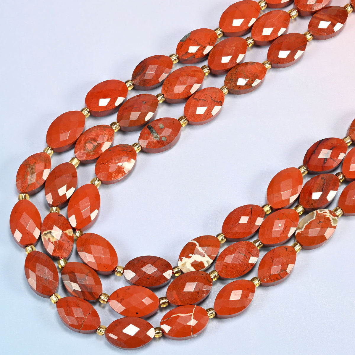Flower red jasper faceted flat oval beads in several strands curved into a wide U, brick red with cream patterns