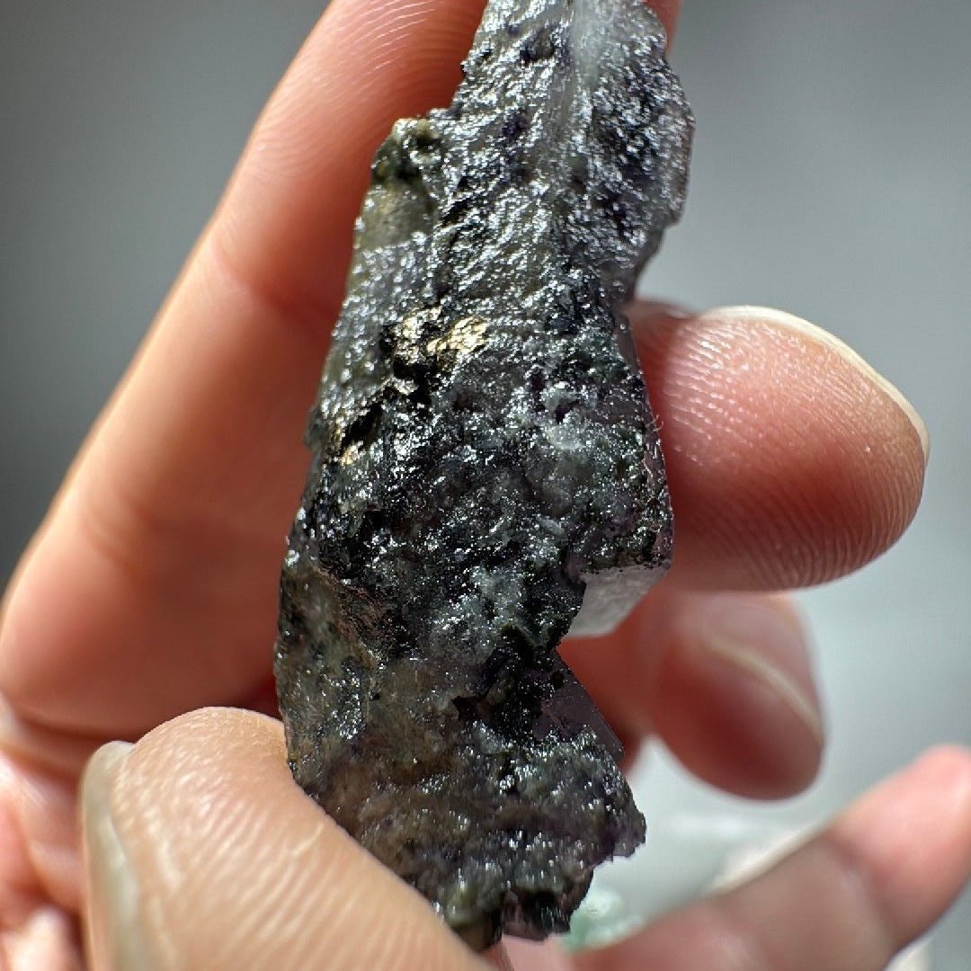 Rough back face of the fluorite, textured and glinting with tiny crystal points