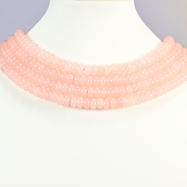 Rose Quartz Color dyed jade gemstone rondelle beads shown on a display bust as a layered collar, several strands stepping down in a row