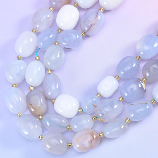 Smooth chalcedony ovals curving through a shallow arc, translucent white beside grey-lavender