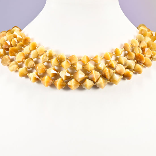 Gold tiger eye bicone beads curved into a collar, the cat's eye line sliding across each bead as the angle changes.