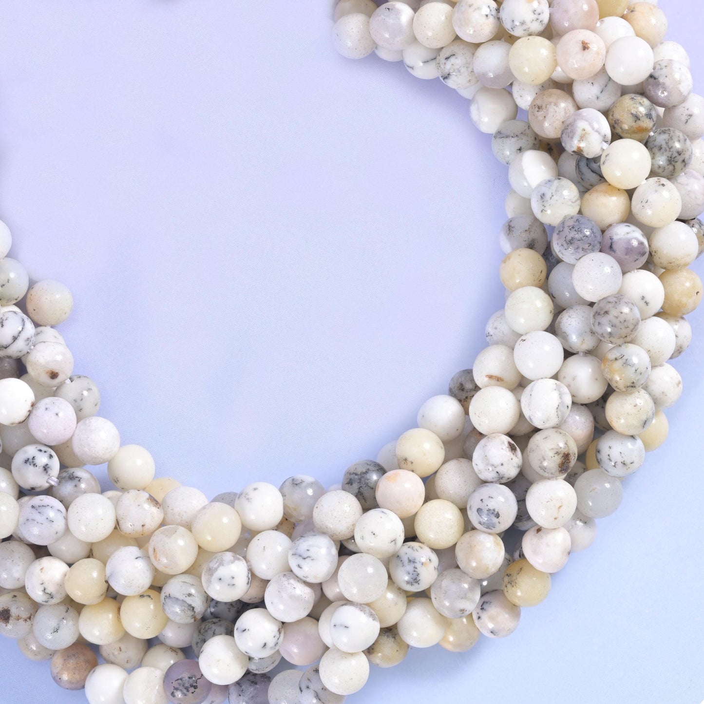 Creamy ivory and soft grey-white with fine dendritic speckling, opaque with a gentle waxy glow