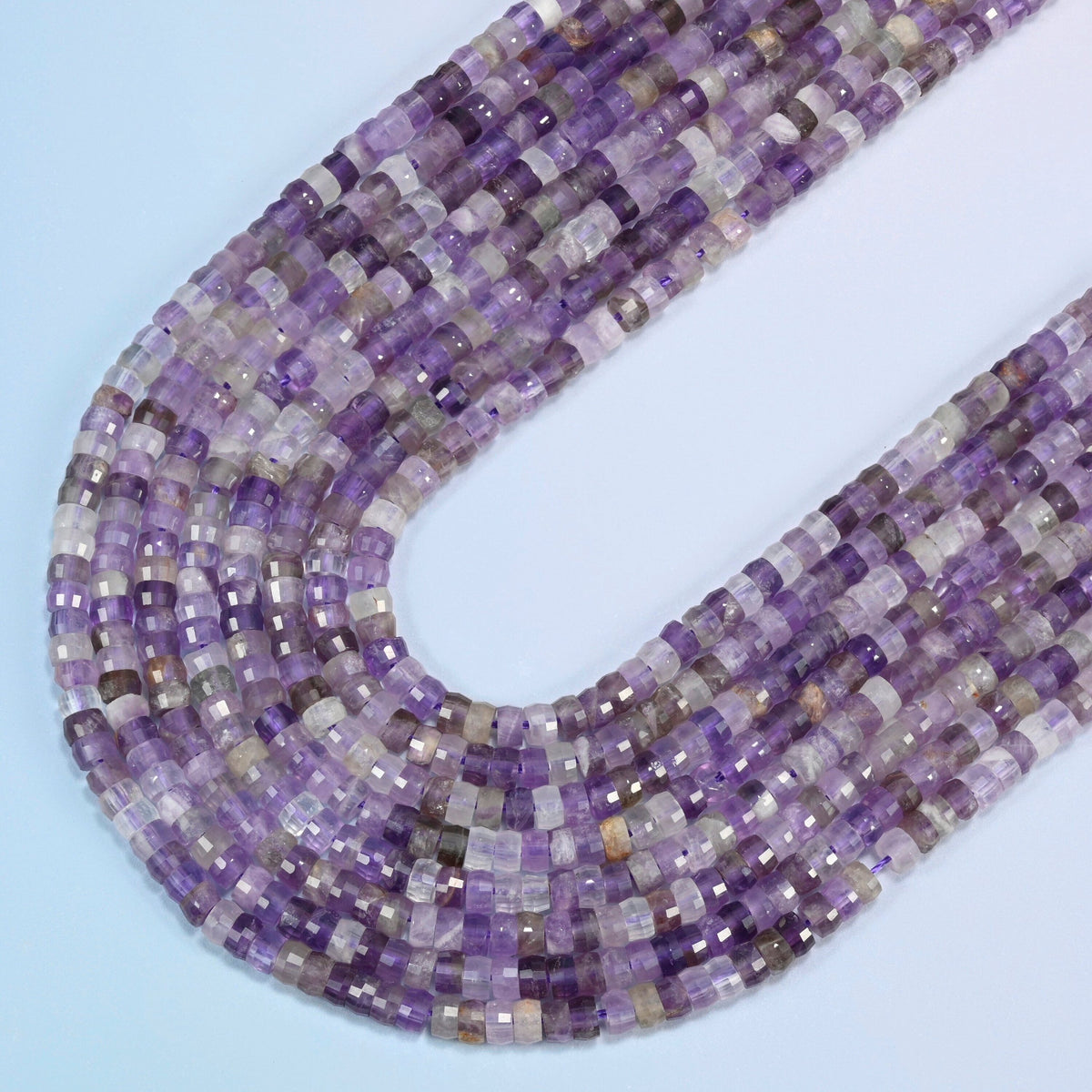 Amethyst faceted heishi disc beads in several strands curved into a wide U, purple, lavender and clear stone