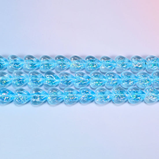 Iridescent light blue heart glass beads seen side on, showing the 8.54mm puffed thickness of each heart