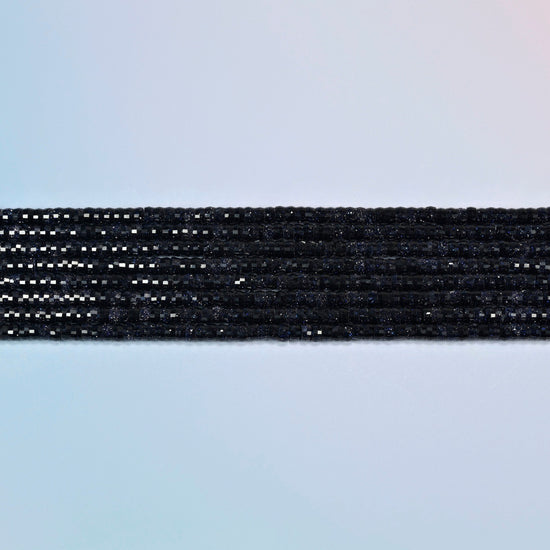 Several strands of blue sandstone faceted heishi disc beads laid in straight rows