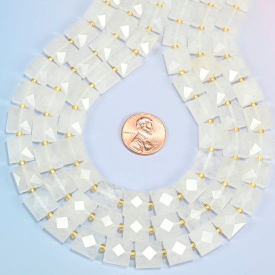 Clear quartz faceted flat square strands formed into a teardrop loop around a US penny for scale