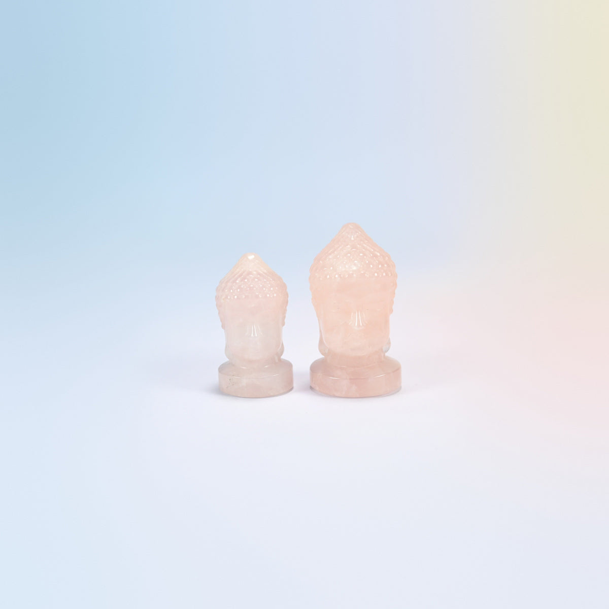 Natural rose quartz Buddha head carvings in light pink, 1.5 inch and 2 inch side by side