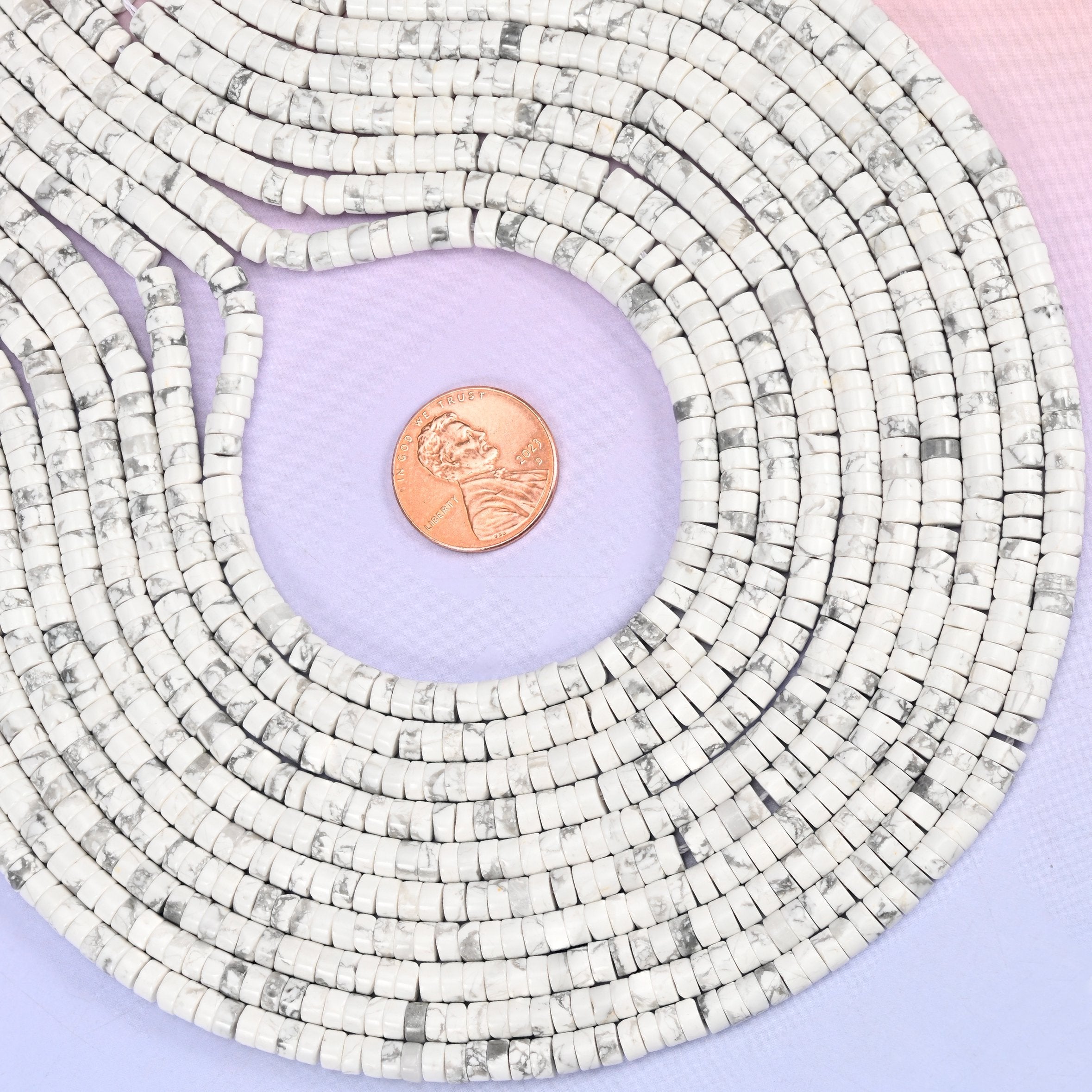 Natural White Howlite smooth heishi disc beads in classic white with characteristic gray veining, finished with a polished, sophisticated look.