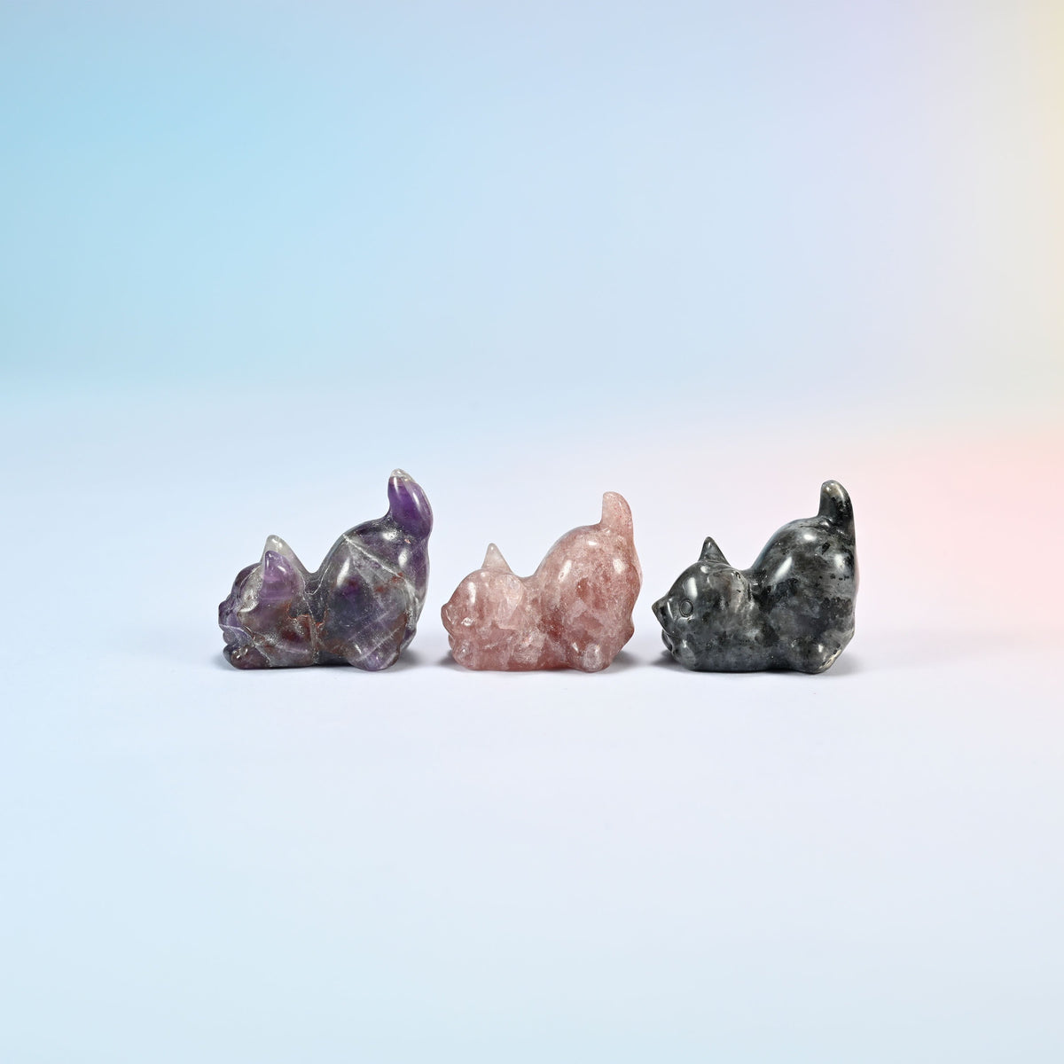 Natural amethyst, strawberry quartz and black labradorite yoga cat carvings seen from the other side, polished smooth all round