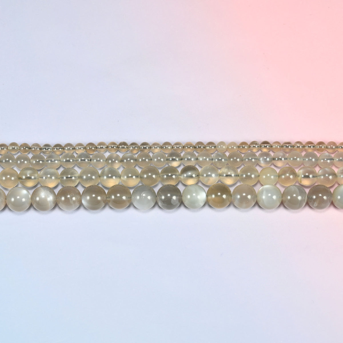 AAA Gray Labradorite smooth round beads in horizontal rows, the bead sizes stepping from small to large