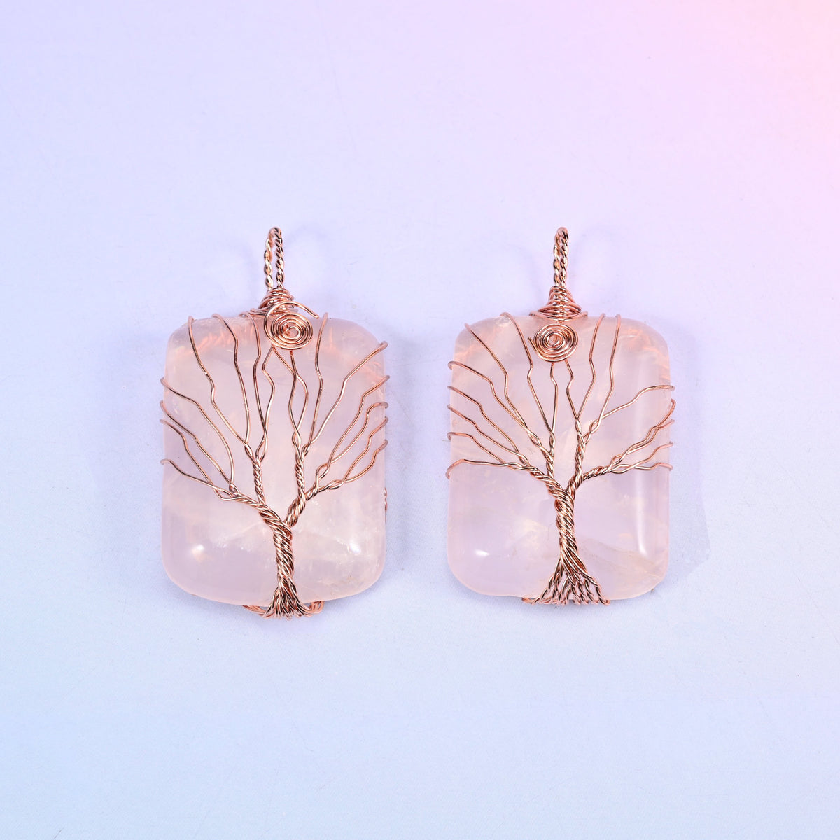 Rectangle Gemstone Tree of Life Pendant in blush pink stone, two pieces side by side with copper wire branches fanned across the polished face.