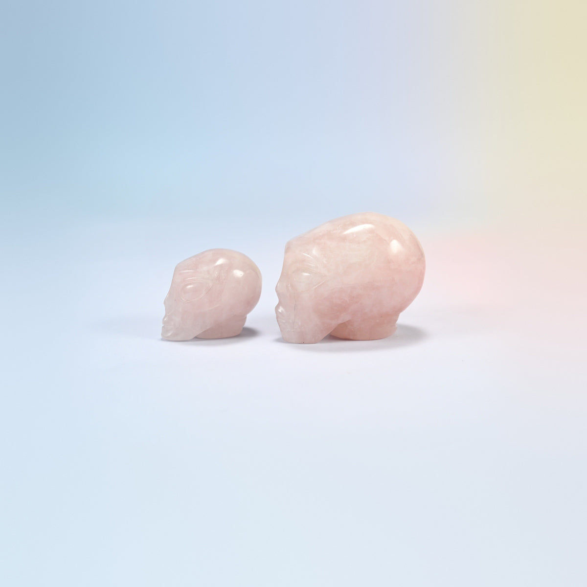Two rose quartz alien head crystal carvings, 1.5 inch and 2 inch, light pink natural stone