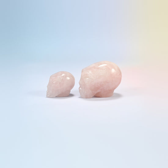 Two rose quartz alien head crystal carvings, 1.5 inch and 2 inch, light pink natural stone