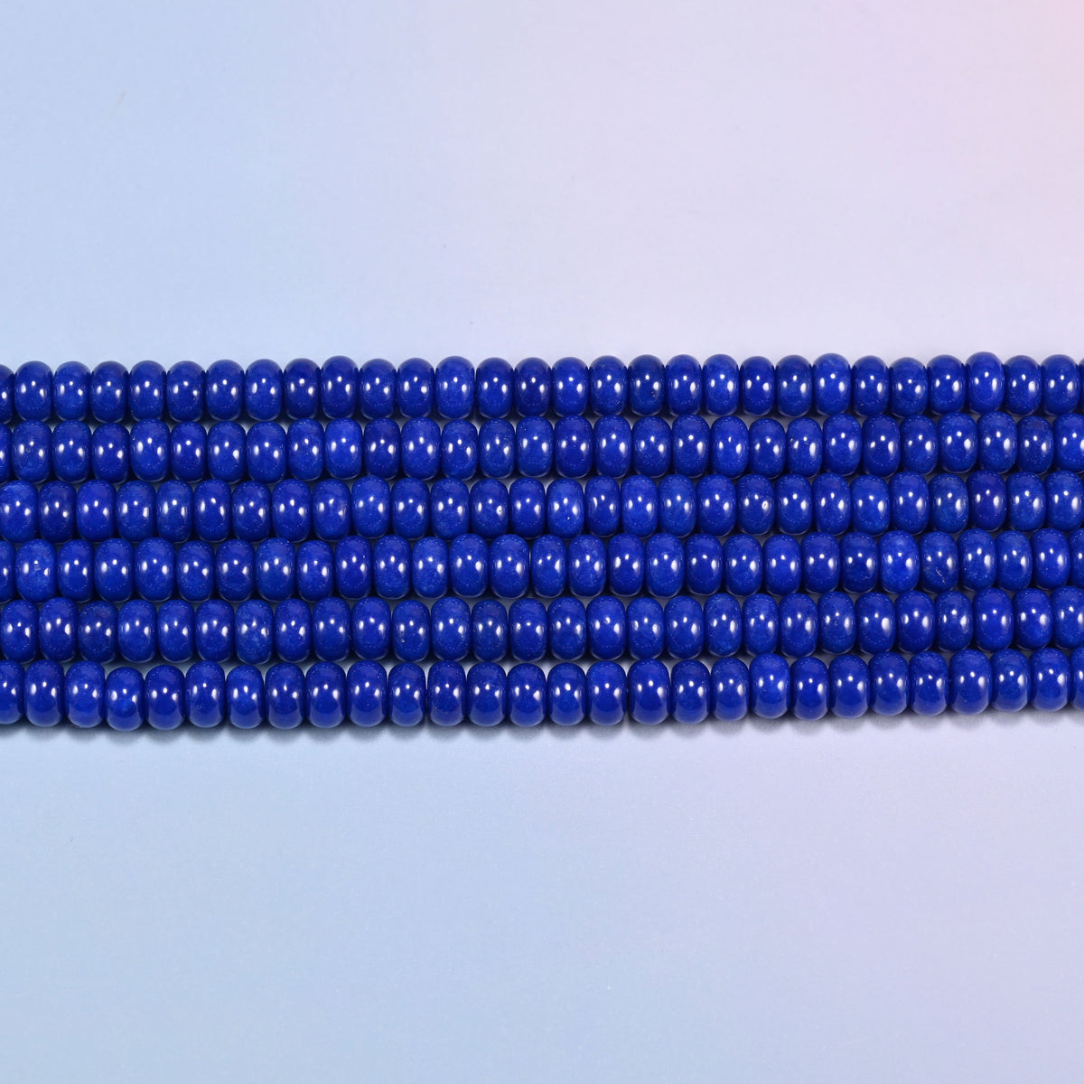 Dark Blue dyed jade gemstone rondelle beads in straight rows, showing the flat 5x8mm disc profile and centre drilling