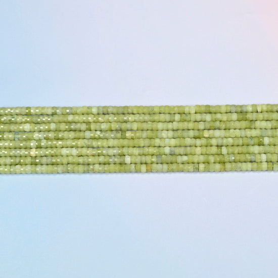 Several strands of South Jade faceted heishi disc beads laid in straight rows