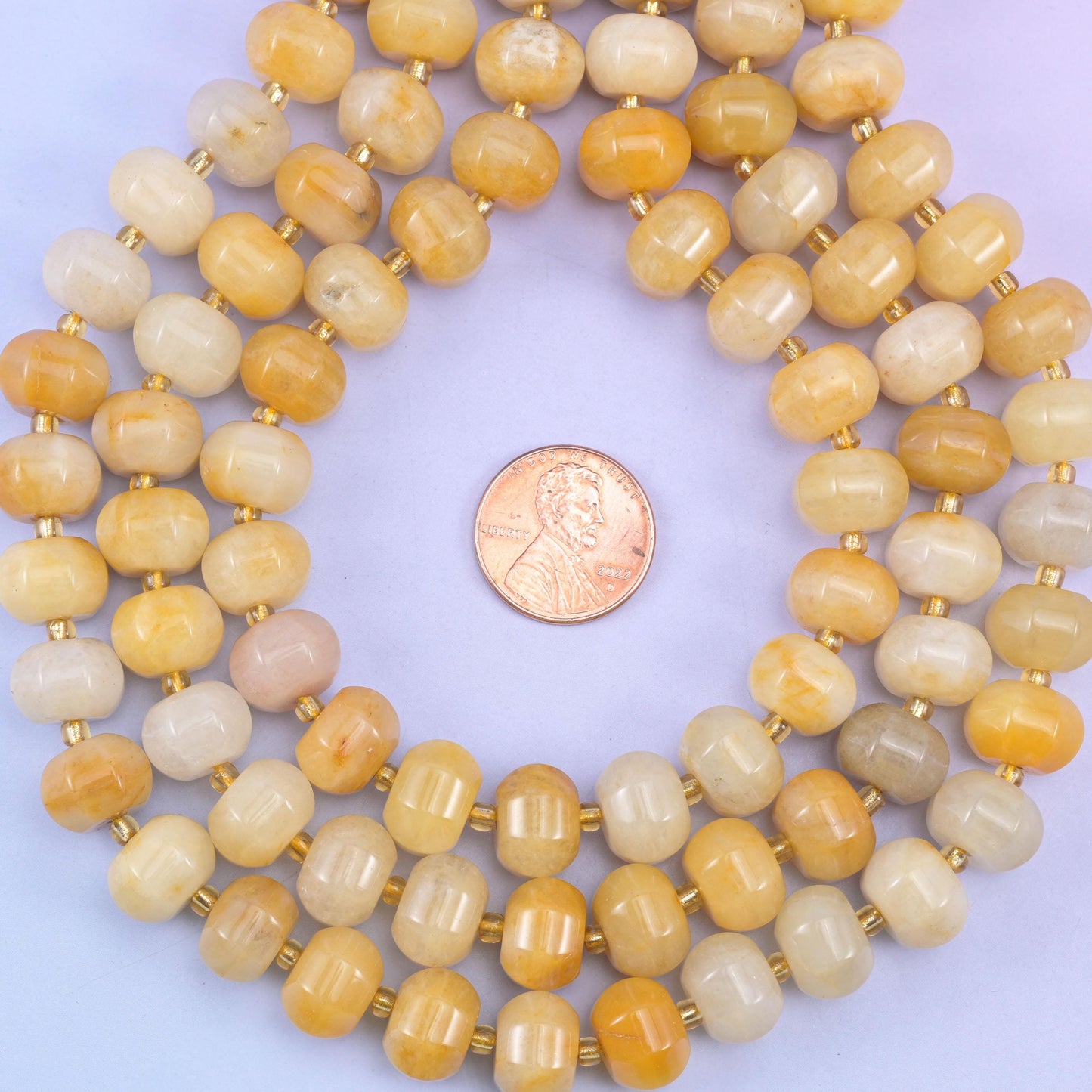 Yellow jade smooth pumpkin beads in warm honey-yellow tones with golden striations