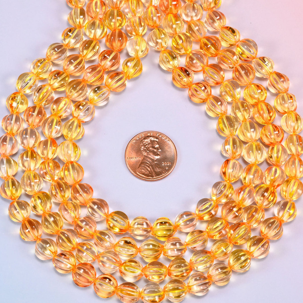 Yellow gold pumpkin glass beads coiled into a wide open ring, gold ribs catching the light.