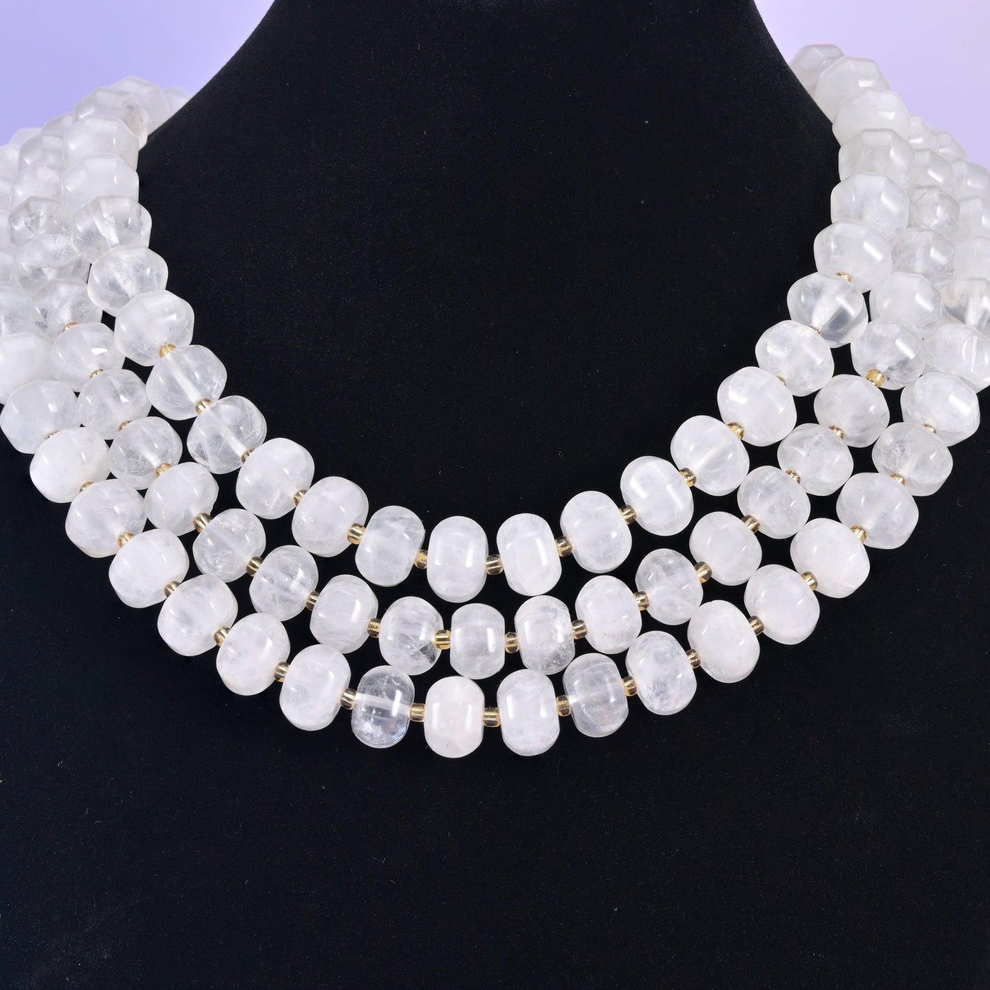 Rondelles on a black display bust, milky white beads standing out against the dark backdrop
