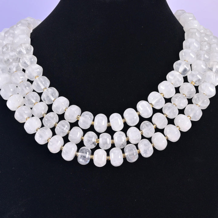 Rondelles on a black display bust, milky white beads standing out against the dark backdrop