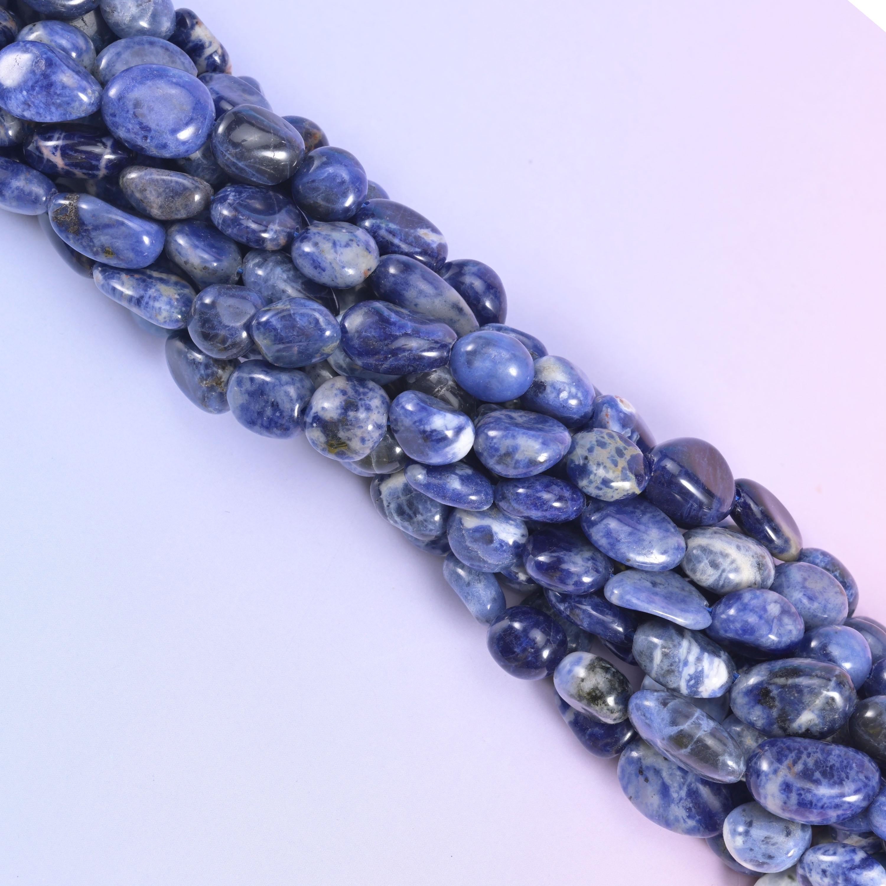 Diagonal run of Sodalite pebble beads across a pale lavender background