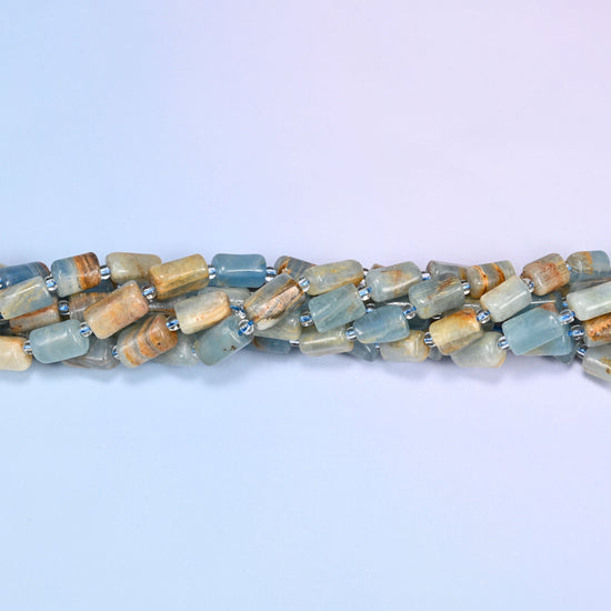 Blue calcite faceted tube beads twisted into a narrow rope running across the frame.