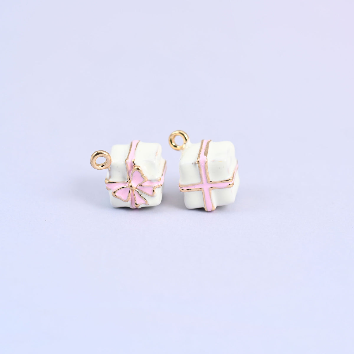 Two white gift box charms with pink enamel ribbon and bow.